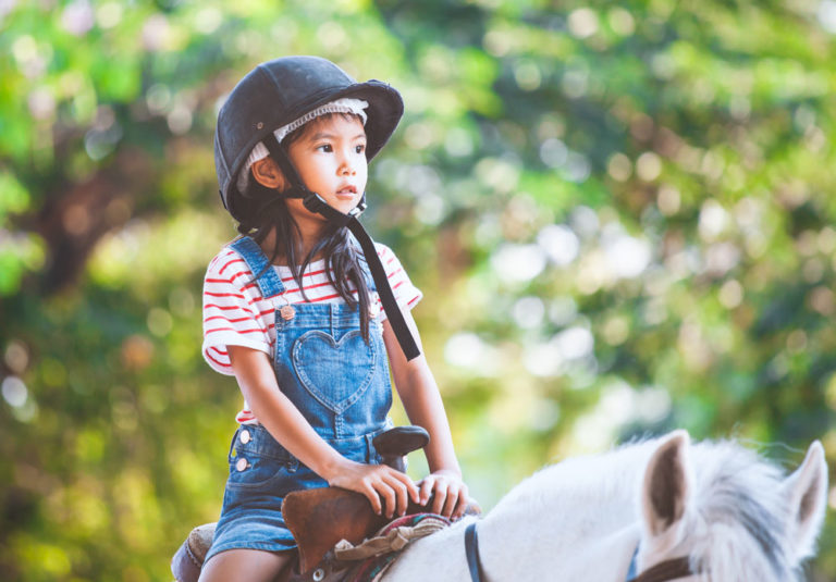 Asian-girl-child-riding-helmet-shorts-iStock-Saslistock-1063527484-1000