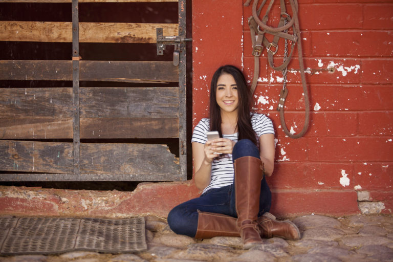 cell-phone-young-woman-sitting-barn-2400