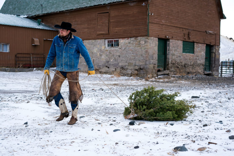 cowboy-dragging-Christmas-tree-with-rope-iStock-Wanderluster-989152338-2400