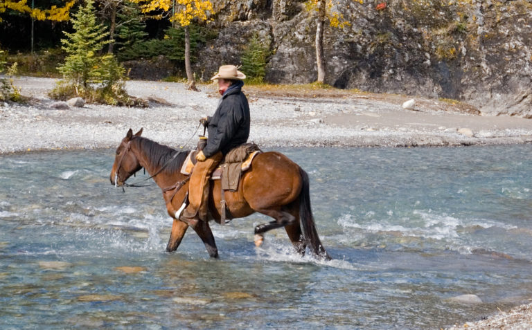 cowboy-fording-stream-mountain-horseback-photos