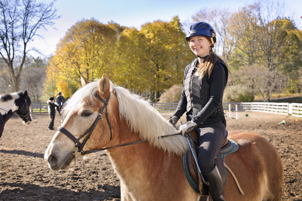 girl-smiling-riding-vest-helmet-outside-group-1