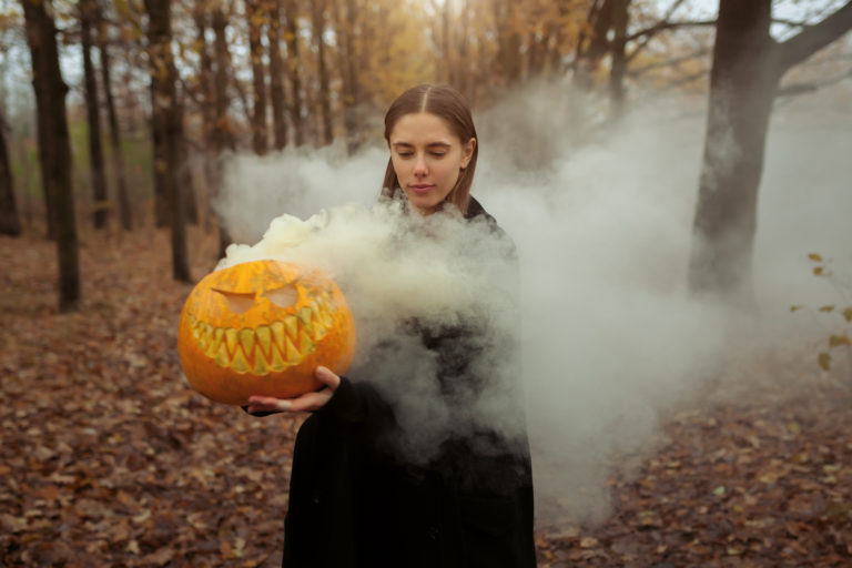 halloween-pumpkin-smoking-girl-in-black-iStock-1033517142-2400