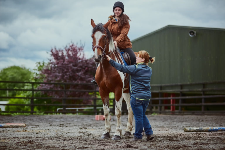 lesson instructor paint horse student iStock-credit PeopleImages 913704870
