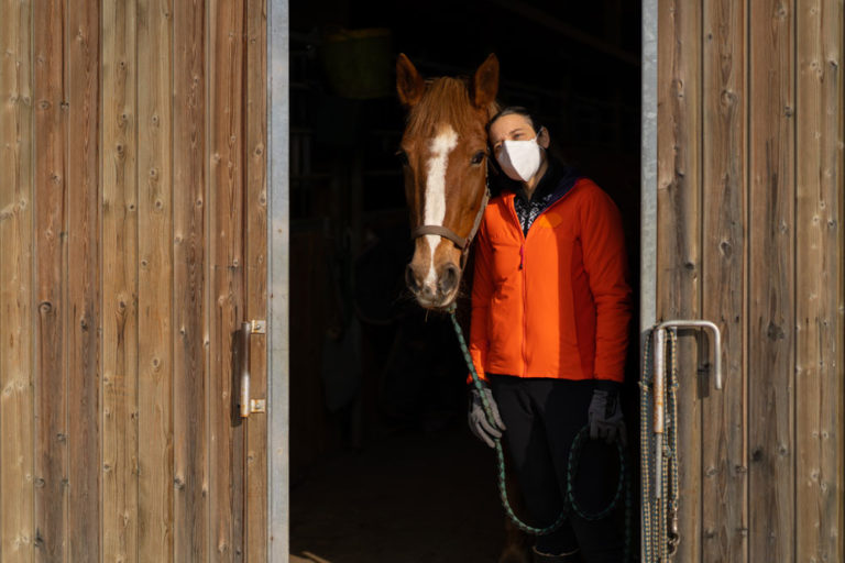 mask-woman-horse-stable-doorway-iStock-Amri-Photo-1301958254-1000