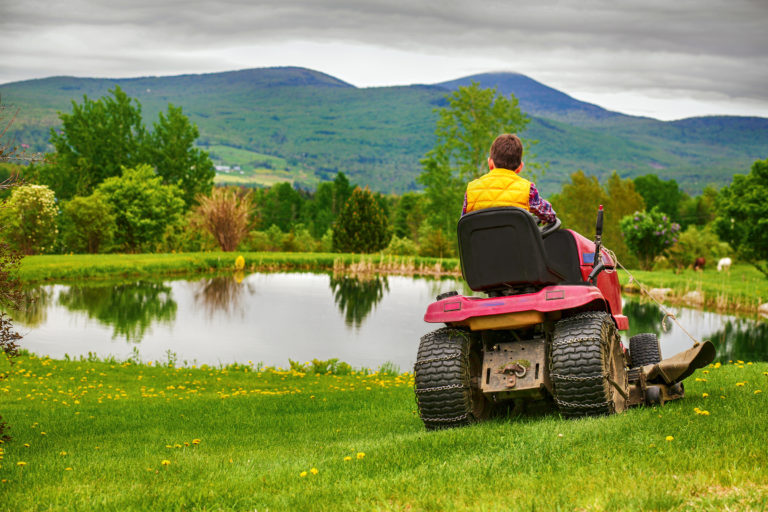mowing-grass-boy-horses-pond-iStock-972733840-2400