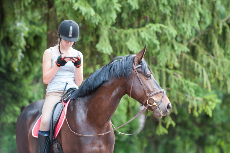 phone-teen-girl-horseback-iStock-Anne-Elizabeth-Photography-889476788-2400